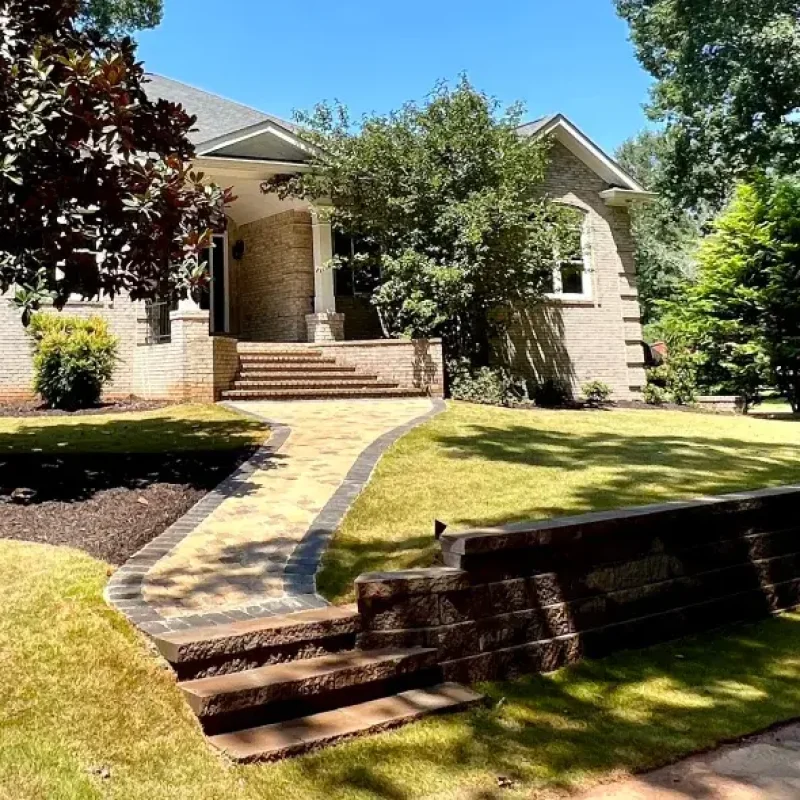 Front complete landscape renovation by Quiett Scapes. Bushes, Trees, sod, walkway, and retaining wall